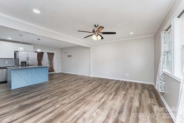 611 King Arthur Dr, Gastonia, NC 28056 - unfurnished living room with wood finished floors, ceiling fan, recessed lighting, and crown molding