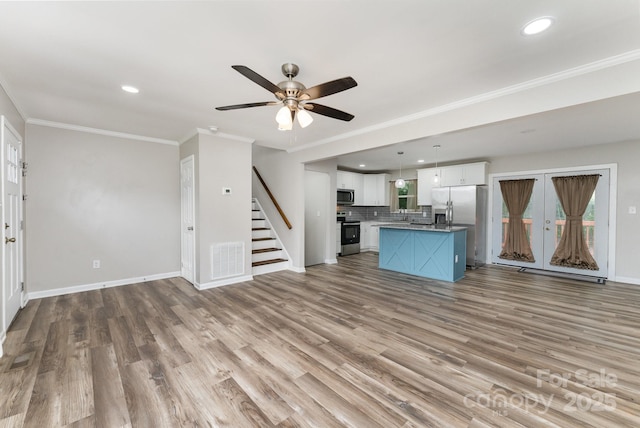 611 King Arthur Dr, Gastonia, NC 28056 - unfurnished living room with stairs, recessed lighting, wood finished floors, a ceiling fan, and ornamental molding