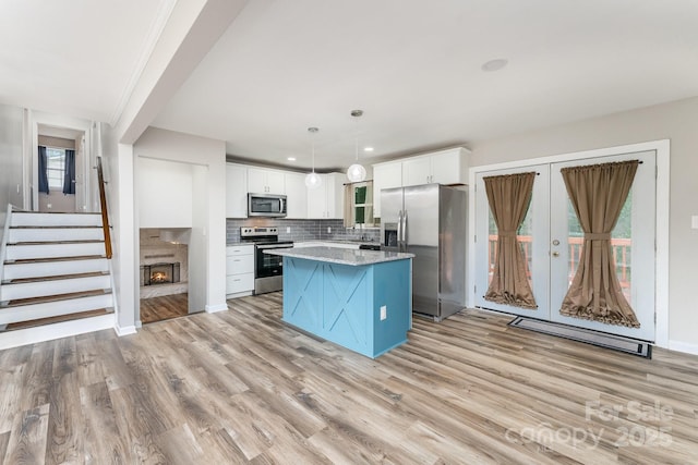 611 King Arthur Dr, Gastonia, NC 28056 - kitchen featuring stainless steel appliances, light wood-type flooring, a center island, white cabinets, and recessed lighting