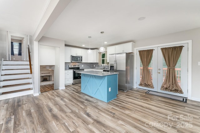 611 King Arthur Dr, Gastonia, NC 28056 - kitchen with appliances with stainless steel finishes, a center island, light wood-style floors, white cabinetry, and recessed lighting