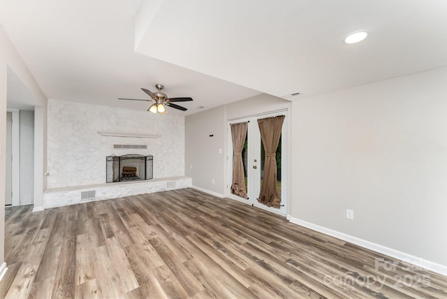 611 King Arthur Dr, Gastonia, NC 28056 - unfurnished living room with a ceiling fan, wood finished floors, and a stone fireplace