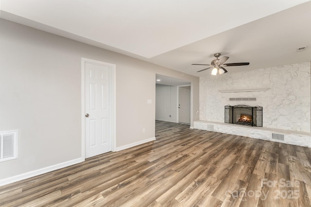 611 King Arthur Dr, Gastonia, NC 28056 - unfurnished living room featuring wood finished floors, a ceiling fan, and a stone fireplace