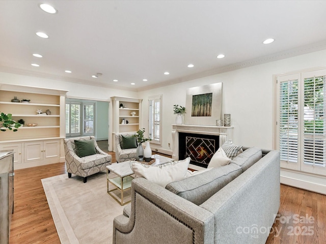 6546 Chestnut Grove Ln, Charlotte, NC 28210 - living room featuring recessed lighting, light wood-type flooring, a warm lit fireplace, and ornamental molding