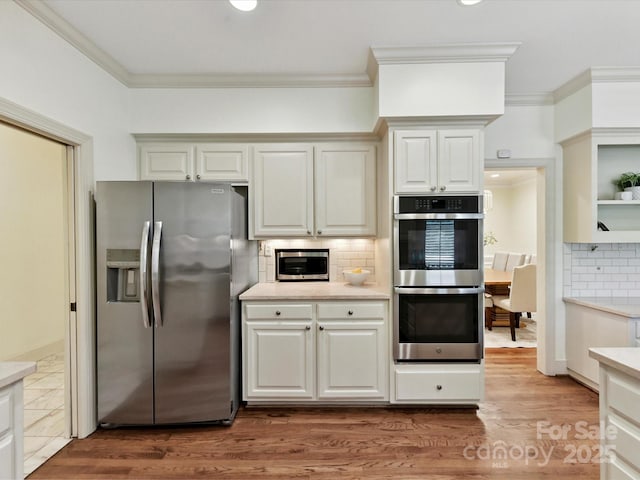 6546 Chestnut Grove Ln, Charlotte, NC 28210 - kitchen with appliances with stainless steel finishes, crown molding, light countertops, decorative backsplash, and wood finished floors