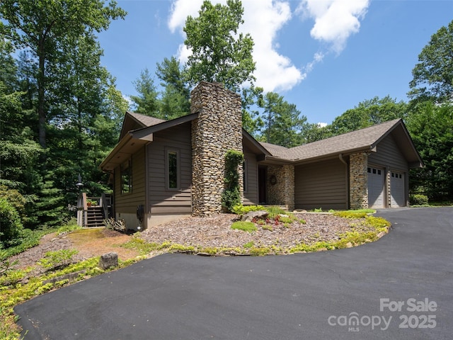 19 Jasmine Pl, Laurel Park, NC 28739 - view of property exterior with a chimney, a garage, driveway, and a shingled roof