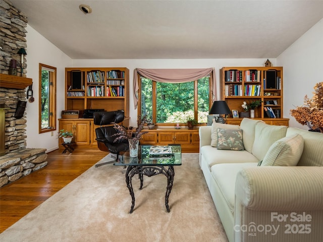 19 Jasmine Pl, Laurel Park, NC 28739 - living room featuring wood finished floors, a stone fireplace, and vaulted ceiling