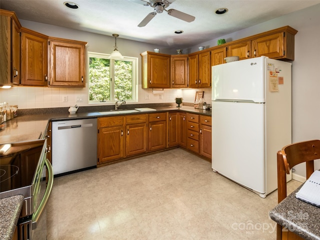19 Jasmine Pl, Laurel Park, NC 28739 - kitchen with dishwasher, freestanding refrigerator, brown cabinets, dark countertops, and recessed lighting