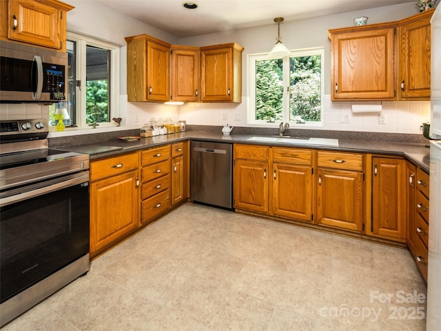 19 Jasmine Pl, Laurel Park, NC 28739 - kitchen with appliances with stainless steel finishes, brown cabinets, dark countertops, and backsplash