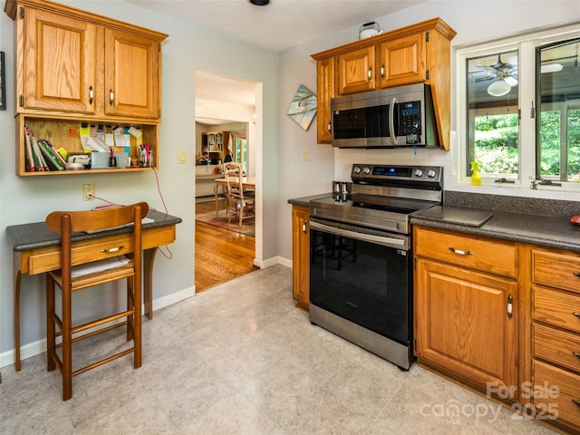 19 Jasmine Pl, Laurel Park, NC 28739 - kitchen featuring stainless steel appliances, dark countertops, brown cabinetry, and ceiling fan