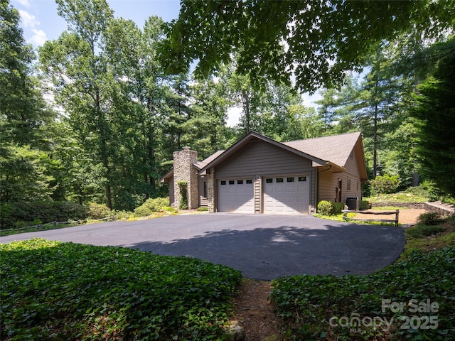 19 Jasmine Pl, Laurel Park, NC 28739 - view of home's exterior with driveway, an attached garage, and a chimney
