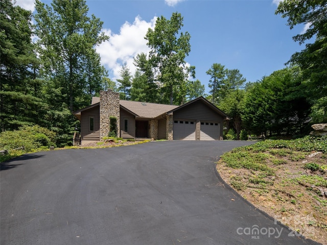 19 Jasmine Pl, Laurel Park, NC 28739 - view of front facade with stone siding, driveway, a garage, and a chimney