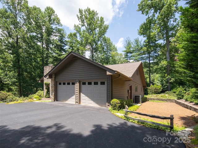 19 Jasmine Pl, Laurel Park, NC 28739 - view of side of home featuring an attached garage, asphalt driveway, and a chimney