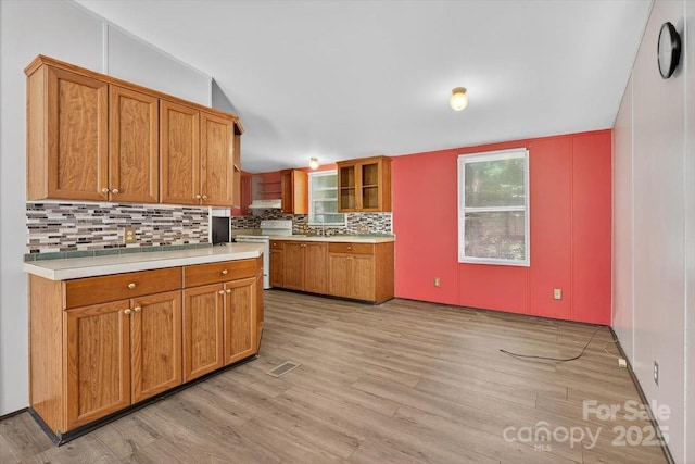 2611 Dallas Stanley Hwy, Stanley, NC 28164 - kitchen with white electric range, light countertops, light wood-style floors, tasteful backsplash, and brown cabinetry