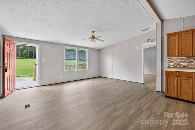 2611 Dallas Stanley Hwy, Stanley, NC 28164 - unfurnished living room featuring ceiling fan, light wood-style floors, and a textured ceiling