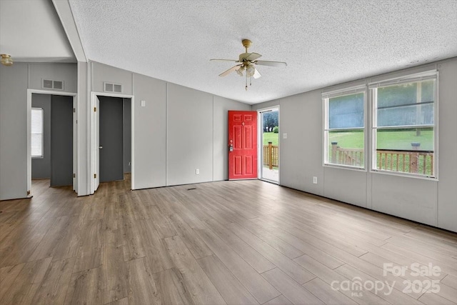 2611 Dallas Stanley Hwy, Stanley, NC 28164 - unfurnished living room featuring vaulted ceiling, a textured ceiling, ceiling fan, and wood finished floors