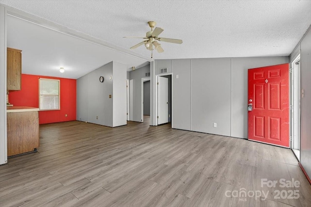 2611 Dallas Stanley Hwy, Stanley, NC 28164 - unfurnished living room with a ceiling fan, wood finished floors, a textured ceiling, and lofted ceiling