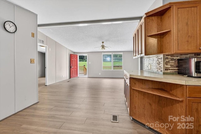 2611 Dallas Stanley Hwy, Stanley, NC 28164 - kitchen with open shelves, a ceiling fan, light wood-style flooring, light countertops, and a textured ceiling