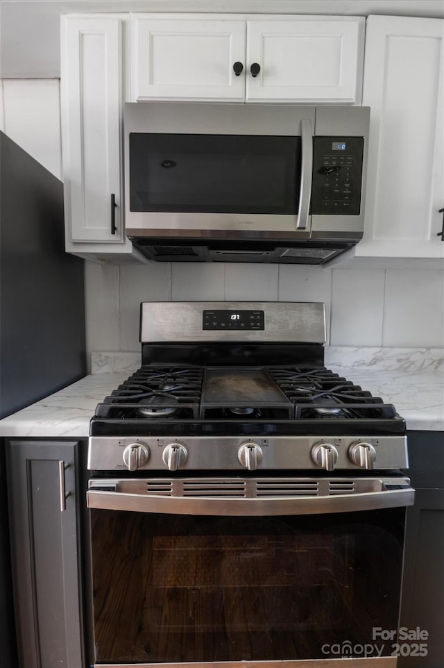 351 Dove Haven Ln, Hendersonville, NC 28791 - kitchen with stainless steel appliances, light stone counters, white cabinetry, and decorative backsplash