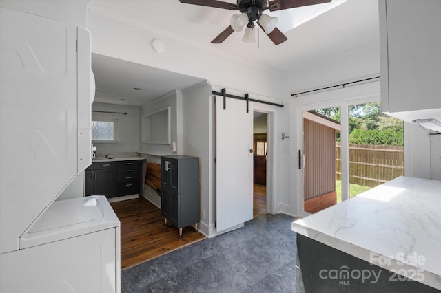 351 Dove Haven Ln, Hendersonville, NC 28791 - kitchen with stacked washer / dryer, a ceiling fan, light countertops, a barn door, and crown molding