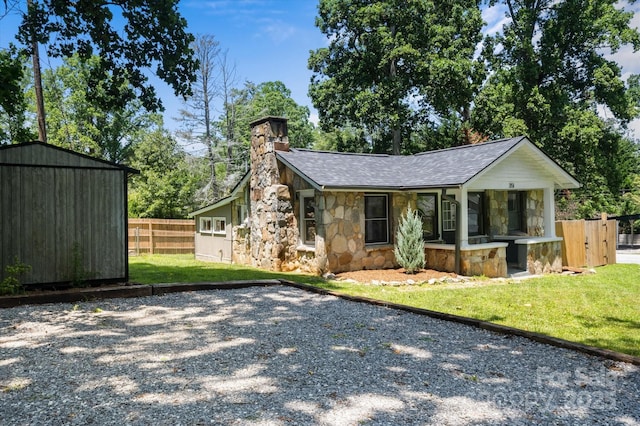 351 Dove Haven Ln, Hendersonville, NC 28791 - view of front of property with stone siding, roof with shingles, a chimney, a storage shed, and gravel driveway
