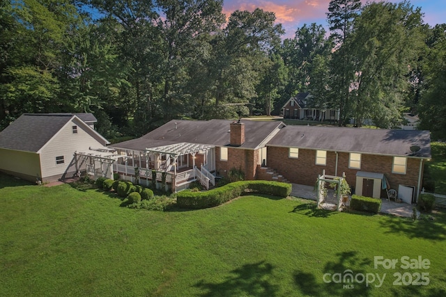 3333 Tanglewood Dr, Rock Hill, SC 29732 - back of property at dusk with an outdoor structure, a yard, a chimney, and brick siding