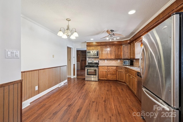 3333 Tanglewood Dr, Rock Hill, SC 29732 - kitchen featuring appliances with stainless steel finishes, a ceiling fan, dark wood-type flooring, crown molding, and wainscoting