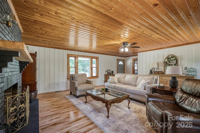 6939 Knob Ave, Connelly Springs, NC 28612 - living room with wooden ceiling, light wood-style floors, a fireplace, a ceiling fan, and wood walls