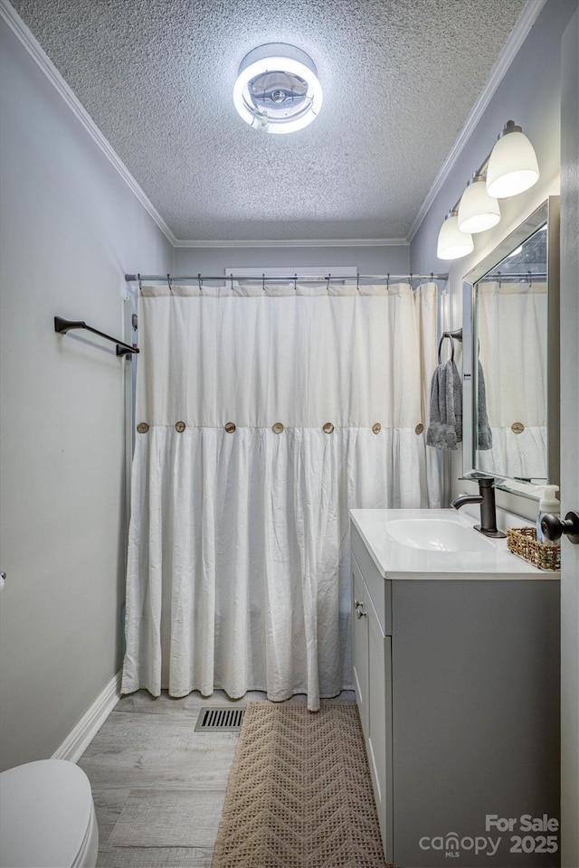 6939 Knob Ave, Connelly Springs, NC 28612 - bathroom with vanity, a textured ceiling, wood finished floors, and crown molding