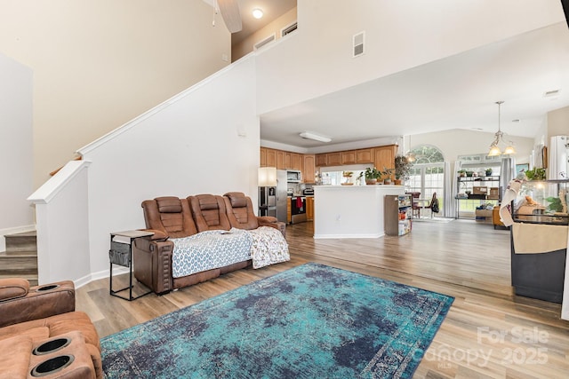 5128 Balsam Bark Ln, Fort Mill, SC 29708 - living room featuring light wood-style flooring, stairway, a chandelier, and vaulted ceiling