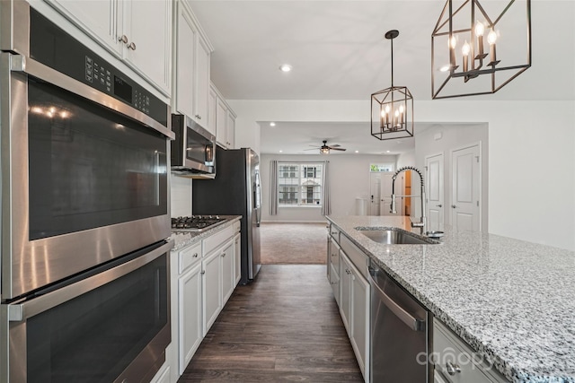 5037 Patton Dr, Gastonia, NC 28056 - kitchen with appliances with stainless steel finishes, a chandelier, a ceiling fan, dark wood-type flooring, and white cabinetry