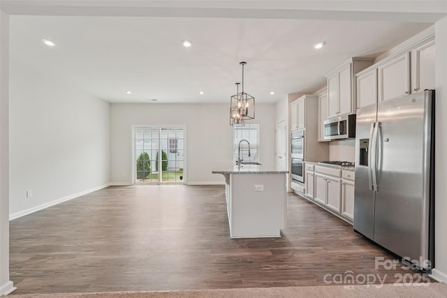 5037 Patton Dr, Gastonia, NC 28056 - kitchen featuring appliances with stainless steel finishes, dark wood-style floors, a center island with sink, light stone countertops, and recessed lighting