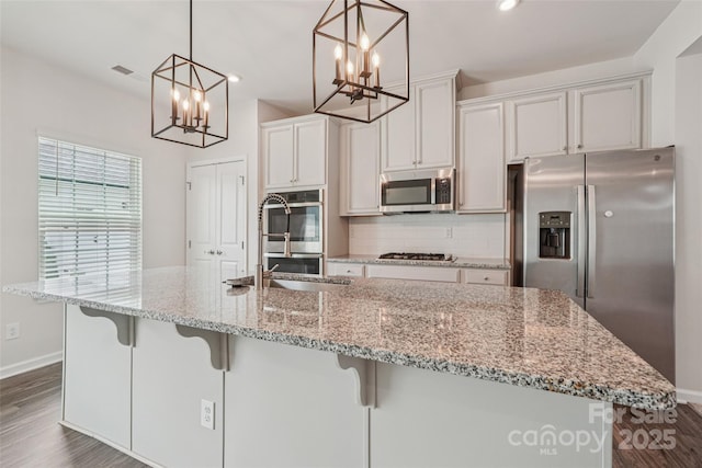 5037 Patton Dr, Gastonia, NC 28056 - kitchen with stainless steel appliances, a chandelier, dark wood-type flooring, decorative backsplash, and a large island with sink