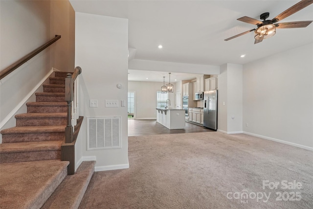 5037 Patton Dr, Gastonia, NC 28056 - unfurnished living room featuring carpet floors, recessed lighting, ceiling fan, stairs, and a chandelier