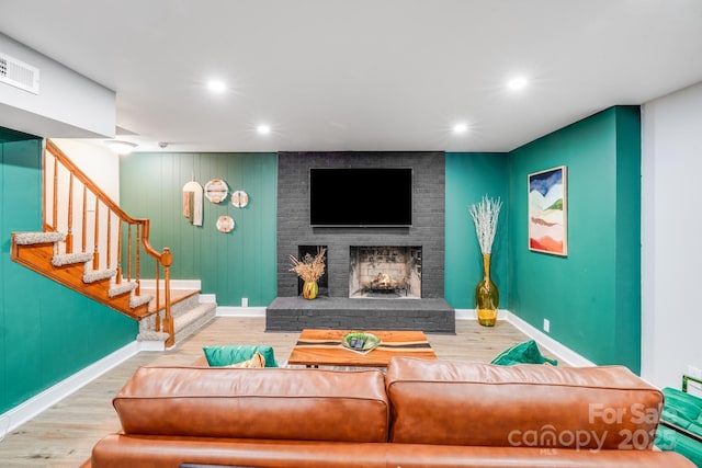 3920 Tilley Morris Rd, Matthews, NC 28105 - living area featuring wood finished floors, stairs, a brick fireplace, and recessed lighting