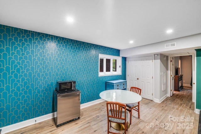 3920 Tilley Morris Rd, Matthews, NC 28105 - dining area featuring wallpapered walls, an accent wall, wood finished floors, and recessed lighting