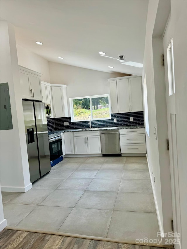 900 Linney Ln, Shelby, NC 28152 - kitchen with stainless steel appliances, electric panel, vaulted ceiling, tasteful backsplash, and white cabinets