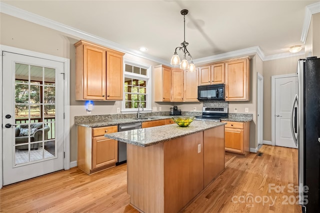 6123 Abergele Ln, Matthews, NC 28104 - kitchen featuring stainless steel appliances, a kitchen island, crown molding, light wood-style flooring, and hanging light fixtures