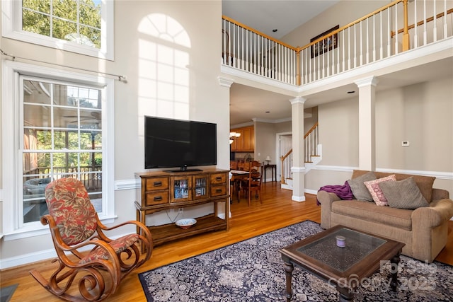 6123 Abergele Ln, Matthews, NC 28104 - living area featuring ornate columns, a towering ceiling, wood finished floors, stairs, and a chandelier