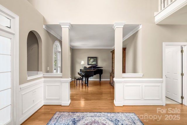 6123 Abergele Ln, Matthews, NC 28104 - entrance foyer with crown molding, light wood-type flooring, wainscoting, arched walkways, and ornate columns