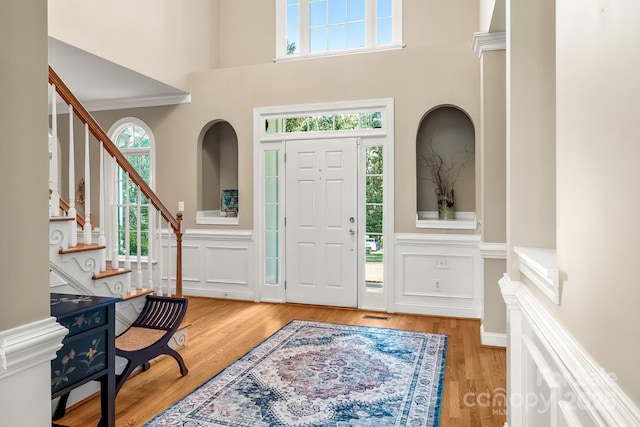 6123 Abergele Ln, Matthews, NC 28104 - entrance foyer featuring a decorative wall, a wainscoted wall, stairway, wood finished floors, and a towering ceiling