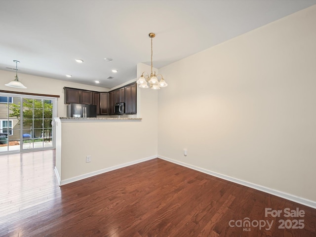 15239 Wrights Crossing Dr, Charlotte, NC 28278 - kitchen featuring stainless steel appliances, dark brown cabinetry, a chandelier, dark wood-style floors, and pendant lighting