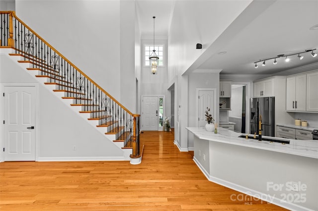 12336 Tantallon Ct, Pineville, NC 28134 - foyer featuring stairway, healthy amount of natural light, light wood-style floors, a towering ceiling, and crown molding