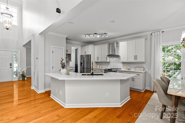 12336 Tantallon Ct, Pineville, NC 28134 - kitchen with wall chimney range hood, appliances with stainless steel finishes, crown molding, plenty of natural light, and light wood-style floors