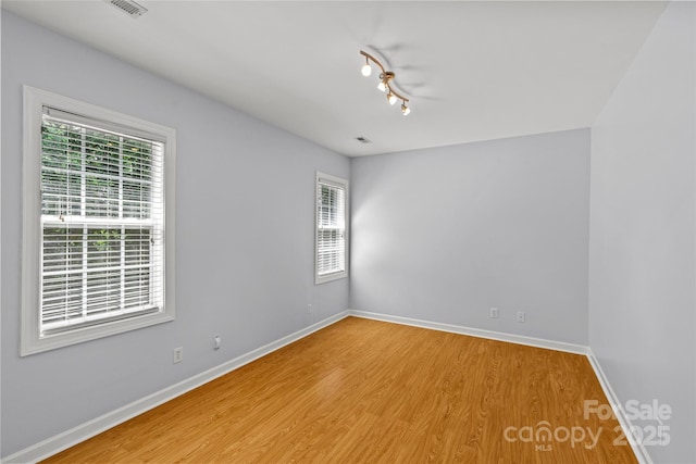 12336 Tantallon Ct, Pineville, NC 28134 - spare room with healthy amount of natural light, wood finished floors, and rail lighting