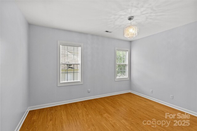 12336 Tantallon Ct, Pineville, NC 28134 - empty room featuring plenty of natural light, wood finished floors, and a chandelier