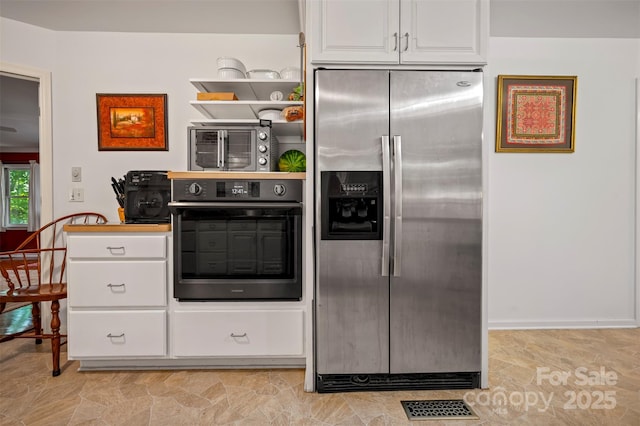 467 Winners Cir, Tryon, NC 28782 - kitchen featuring stainless steel fridge with ice dispenser, oven, and white cabinetry