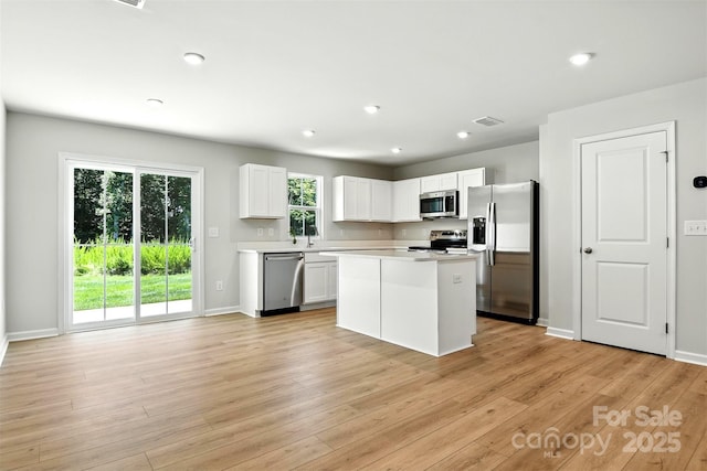 1525 39th Avenue Loop NE Unit 4, Hickory, NC 28601 - kitchen featuring stainless steel appliances, white cabinets, light countertops, light wood-type flooring, and a center island