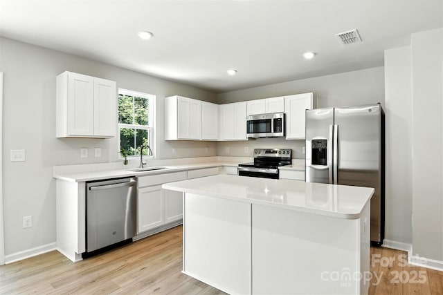 1525 39th Avenue Loop NE Unit 4, Hickory, NC 28601 - kitchen with appliances with stainless steel finishes, light wood-type flooring, white cabinetry, a center island, and light countertops