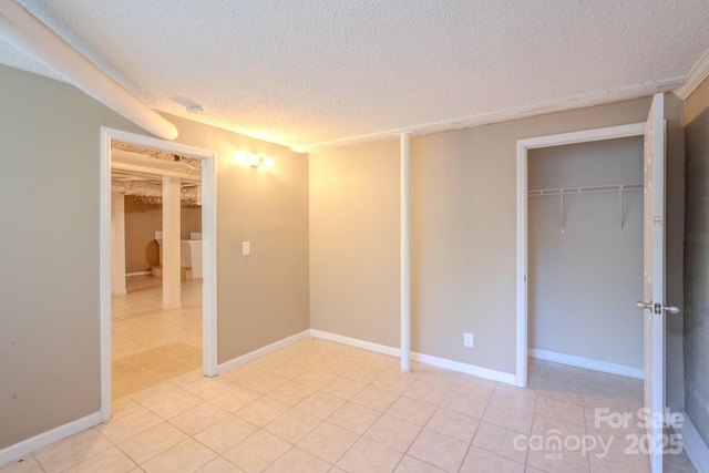 2519 Abelwood Rd, Charlotte, NC 28216 - unfurnished bedroom featuring a textured ceiling, light tile patterned flooring, and a closet