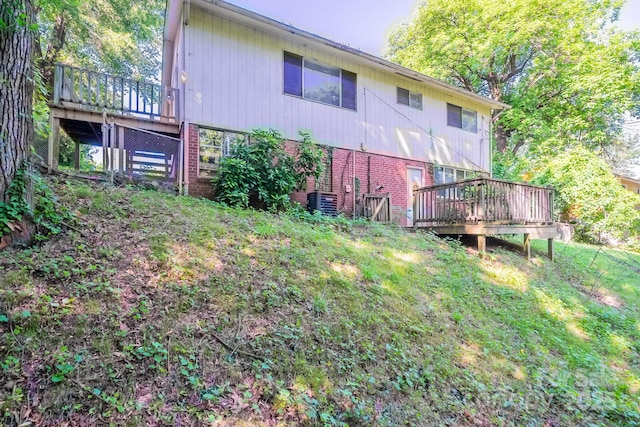 2519 Abelwood Rd, Charlotte, NC 28216 - back of house featuring a deck, brick siding, and a yard